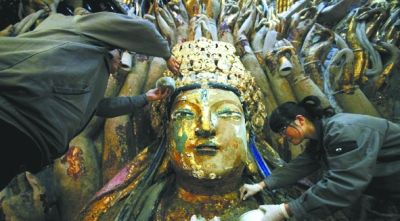 工作人员对千手观音进行修复