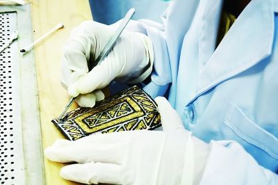 2013年7月18日，甘肃省考古研究所的专业人员正在实验室中修复马家塬战国墓地出土的车辆金属配件。光明日报记者李韵摄