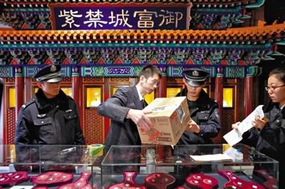 执行法官将故宫内一文玩店的商品装进箱子，并贴上封条