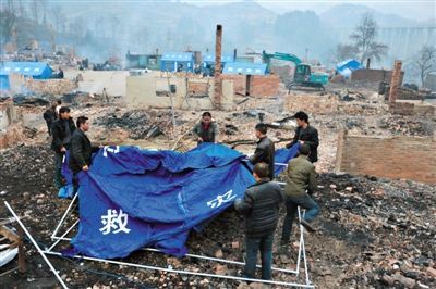 1月26日，报京侗寨的村民搭建政府发放的临时帐篷开展自救。