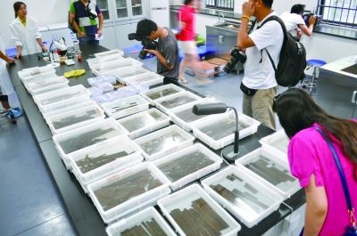 　　2013年7月21日，省考古研究所铜官窑基地。兔子山遗址目前出土了1万多枚简牍，包括木牍和竹简，保存良好，文字以毛笔墨书。实习记者 李健 摄