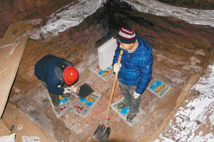 为保护文物，技术人员脚下垫着塑料袋记者 王晓光 摄