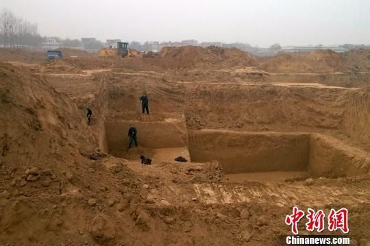 两个相邻的墓葬，有大型挖掘机在施工。 王中举 摄