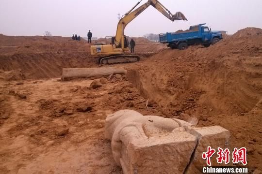 两个相邻的墓葬，有大型挖掘机在施工，散落在地上的石兽雕刻已经裂缝，足以伸下手指。 王中举 摄