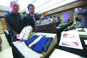 昨天，在中国人民抗日战争纪念馆，台湾抗日志士吕赫若之子吕芳雄（左）、萧道应之子萧开平（右）将各自父亲在抗日时期穿过的衣物和使用过的手提箱摆放在捐赠台上。本报记者 饶强摄