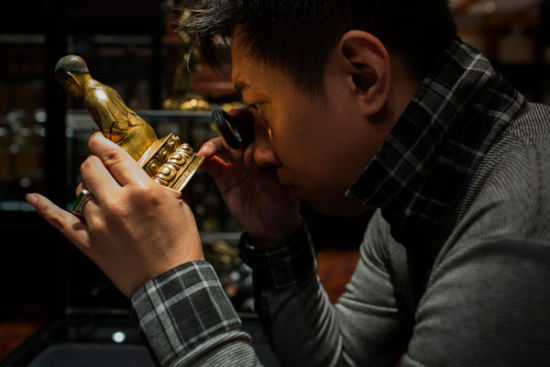 一个潜在的买家在北京今年的一次拍卖会上查看一件拍卖品。