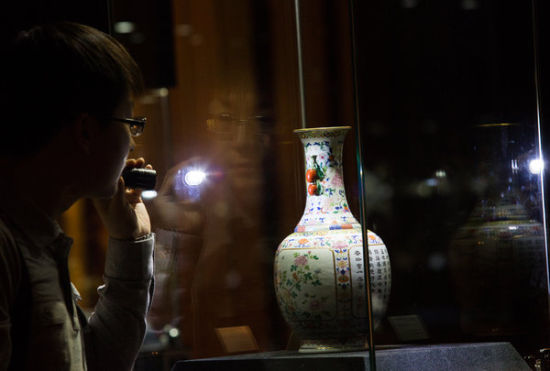 一名观客在中国嘉德拍卖举行的一场售展上细看一只印有乾隆落款的花瓶。