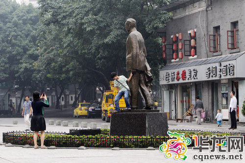 爬上塑像摆pose，自以为很有“范儿”，殊不知可能恰好丢了自己脸。 记者 罗嘉 摄