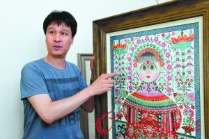 管祥麟向记者介绍库淑兰老人的剪花作品。