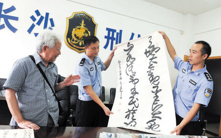 昨日，书法家王友智老人(左一)看到被盗后追回的数十幅书法作品欣喜不已。余志雄 摄