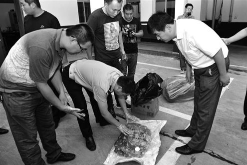 民警在仔细清点收缴来的被盗古衣被