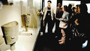 专家为观众讲解展出文物。 （资料图片）齐洁爽 摄