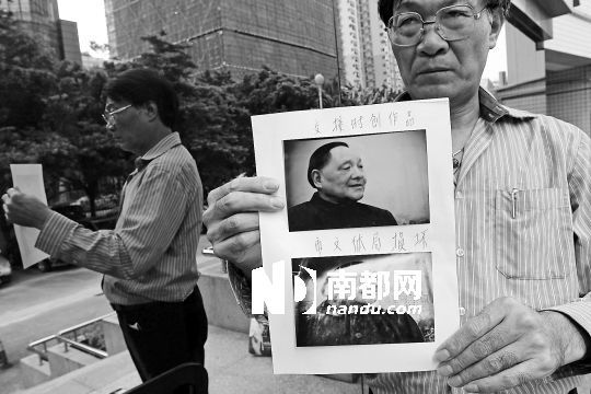 昨日下午，深圳福田法院门前，画家姚景山在开庭前手拿被损坏的油画前后对比相片。南都记者 徐文阁 摄