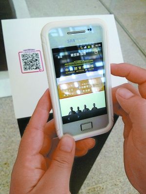 参观者在国博的展品前扫描二维码，可获得的信息十分有限。  　　本报记者 陈涛摄