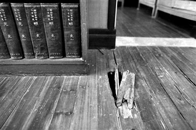 茅盾故居起居室的地板已经腐烂，书籍也长了霉斑。