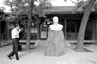 7月19日，茅盾故居，茅盾的孙子沈韦宁在爷爷的雕像前。他呼吁要妥善管理茅盾故居和遗物。新京报记者 薛珺 摄