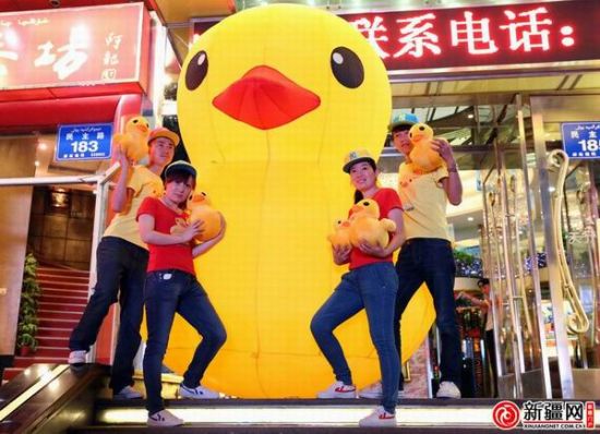 7月10日，民主路一商家门前摆放了一只大黄鸭吸引顾客。（记者刘志龙摄）