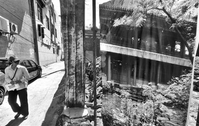 昨日，地安门大街，一位市民路过雁翅楼复建工地。新京报记者 浦峰 摄