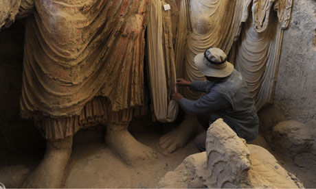 梅斯-阿亚纳克地区的一座古寺，阿富汗的一名考古学家用布遮住佛像。