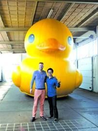 本报记者与“大黄鸭之父”霍夫曼(左)在迷你版的大黄鸭前合影。