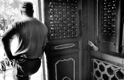 2一旁伺机 男子在帮同伙盯梢，上一次获得的硬币包被放在一边