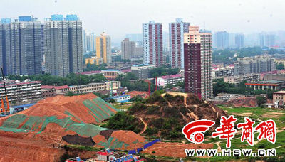 站在附近的一栋高层建筑上鸟瞰韩森冢，看到其北侧和西侧有20多米高的土堆 