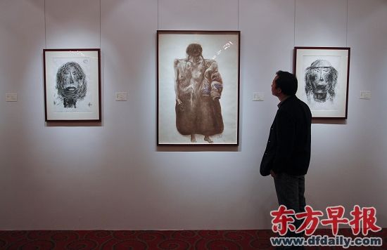 昨日，香港佳士得春季拍卖品巡展上海站，一位市民在欣赏周春芽的炭笔画。 早报记者 张栋 图