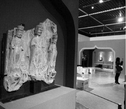 布展现场。左为颇具“青州风格”的东魏贴金彩绘石雕佛三尊立像，国家一级文物。