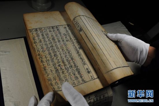 古籍库管理员在展示一本嘉靖13年（1534年）出版的《史记》，这部古籍入选了《陕西省珍贵古籍名录》。