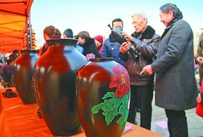 2月21日，在章丘市举办的第四届民俗工艺展上，彩绘黑陶引来不少黑陶爱好者的关注。 记者黄冠林 摄