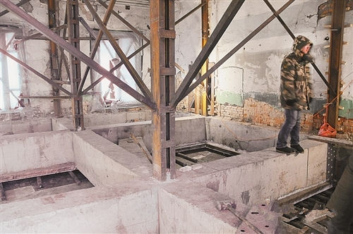 一名工作人员正在将要搬迁的屋内忙碌。