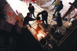 1月10日上午9时许，景德镇市郊一座小型柴窑中，经过两天的烧制和一天的冷却，正在开窑。师傅们把盛装瓷器的匣钵一一运出。 本专稿图片 高剑平