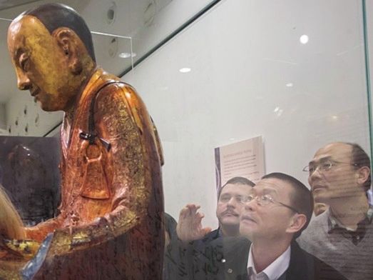 新华社记者杨永前(右一)等被宝像背面的文字吸引。