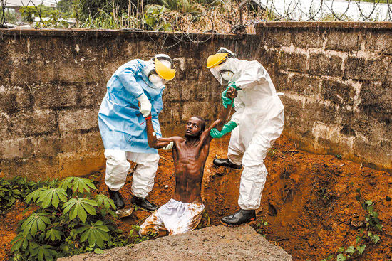 一般新闻类组照一等奖:2014年11月23日,在塞拉利昂黑斯廷斯埃博拉治疗中心,医护人员将因感染埃博拉病毒导致癫狂的患者带回隔离病房。 Pete Muller(美国)/摄