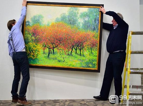 弗兰斯•布罗尔森（右）在悬挂一幅即将展出的朝鲜作品