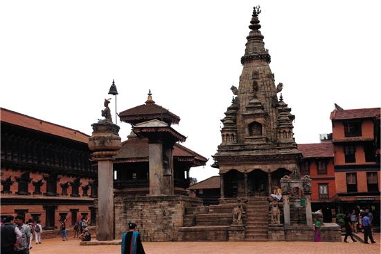 广场的前面是印度教的锡哈拉式塔，旁边是尼泊尔式塔，前面是伽楞频鸟石柱。