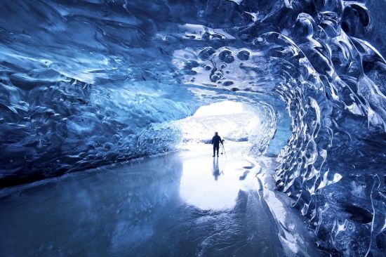 一名游客在冰岛东北部参观壮观的冰洞穴，洞穴四周是被冰冻住的熔硫。（网页截图）