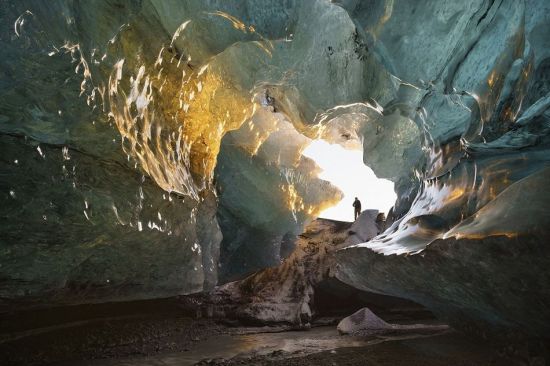 一位游客置身冰洞穴之中，这是由冰面微升，并与喷射出来的热熔岩相遇形成的奇特美景。(网页截图)