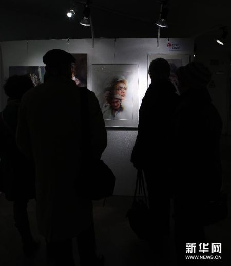 12月2日，人们在德国法兰克福第92届“艺术品”圣诞市场上欣赏艺术家的作品。