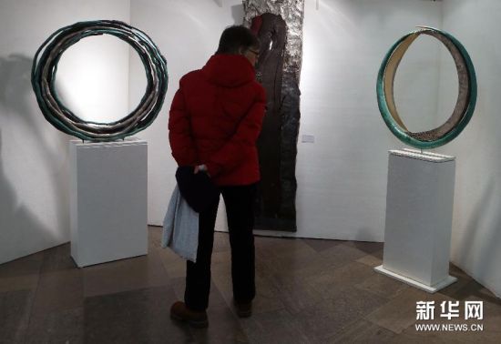 12月2日，人们在德国法兰克福第92届“艺术品”圣诞市场上欣赏艺术家的作品。