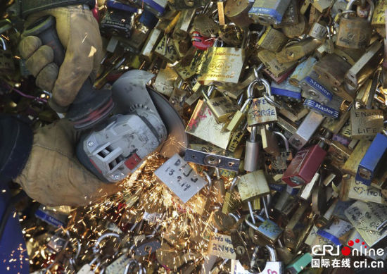 当地时间2014年12月9日，法国巴黎，法国市政厅的雇员在移除巴黎艺术大桥上悬挂的“爱情锁”。