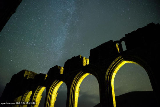 当地时间2014年10月，英国，摄影师摄影师Andrew Whyte镜头下的英国夜景。图为凌晨三点钟璀璨夜空下的布雷肯国家公园兰托尼修道院。