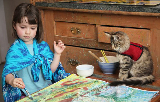 艾瑞斯在画画，“图拉”坐在一旁看着她。