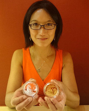 何文津和她的硬币。（左：马年纪念币 右：羊年纪念币）