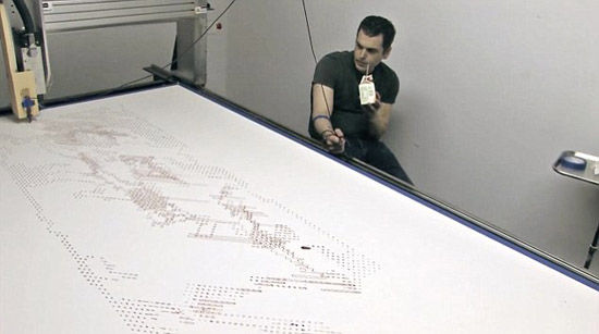 劳森将胳膊上的静脉血管连接到这部自制的打印机上，等待机器打印作品。（网页截图）