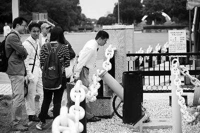 日本游客在仔细端详“致远”舰机关炮 　本版摄/记者 吴海浪