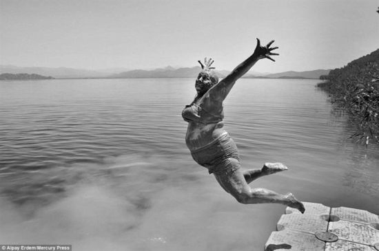 土耳其摄影师阿尔帕·伊艾德姆的作品，一位浑身涂满泥巴的女性跃入湖中。