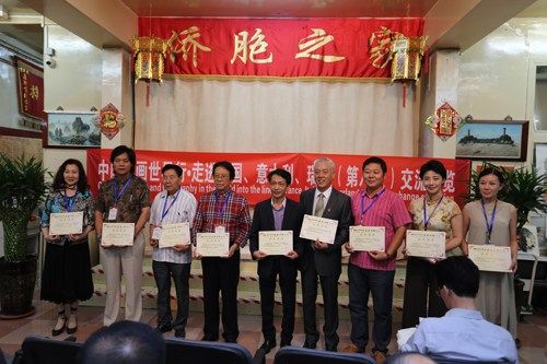 法国华侨华人会主席池万升为参加书画展的艺术家颁发展览证书。（《欧洲时报》/黄冠杰 摄）