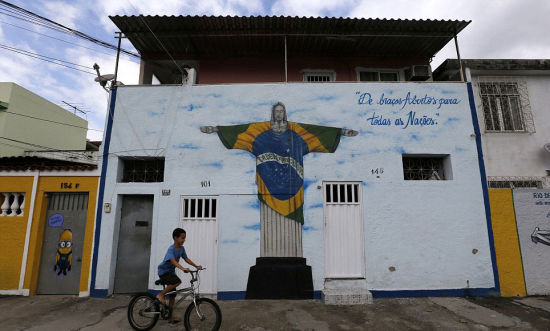 寻救世主：里约市著名耶稣雕像被穿上巴西国旗，旁边写有“欢迎所有国家”的欢迎辞。(网页截图)
