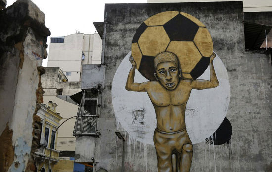 不堪重压：一名小男孩眼中含泪背着一个巨大足球，寓意世界杯开销太大。 (网页截图)